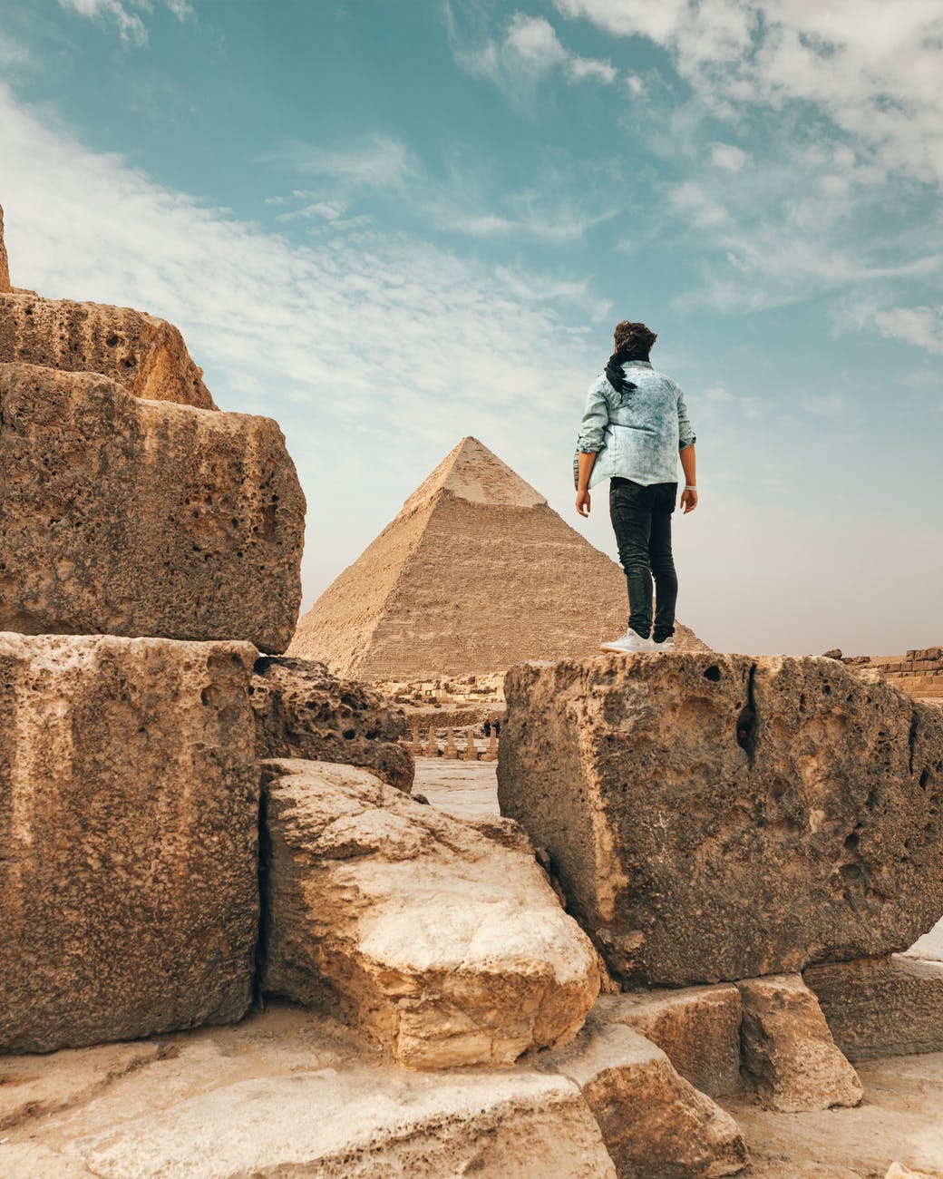 traveler standing on stone monument in desert